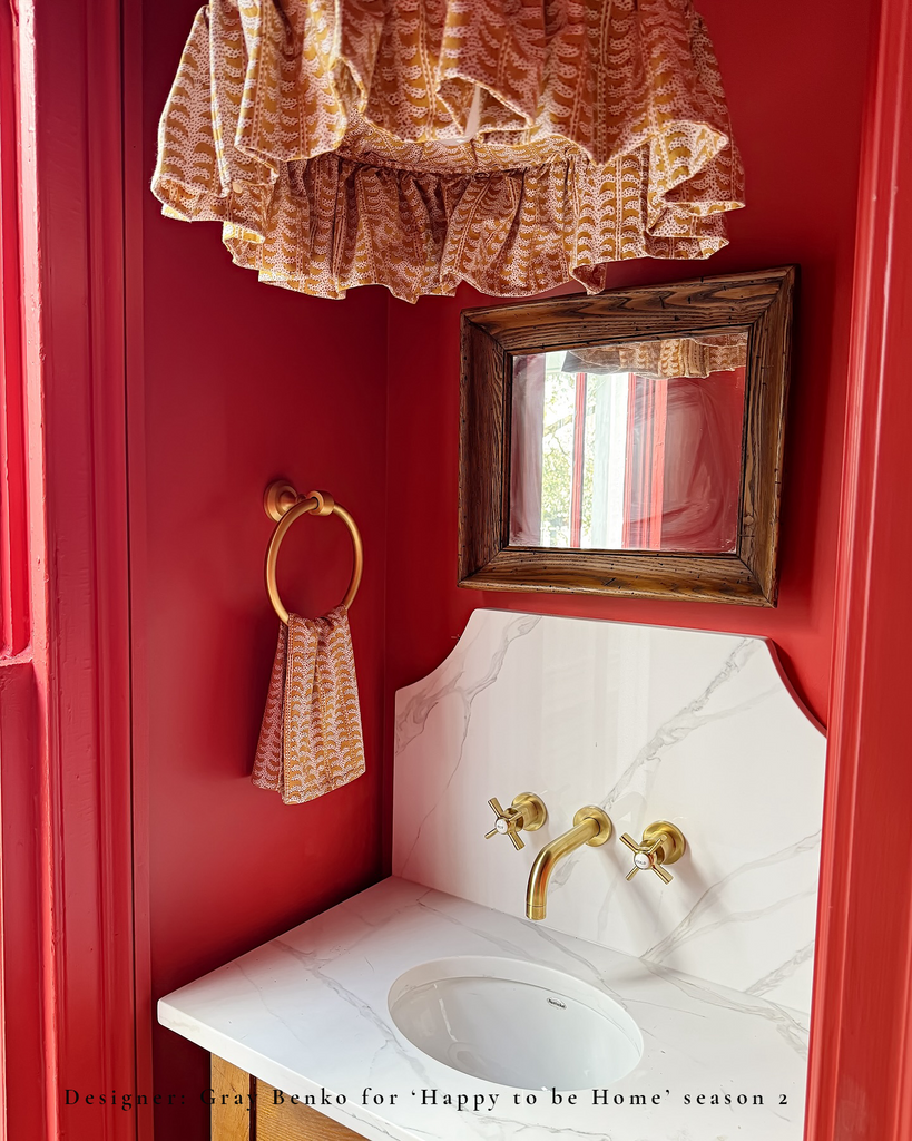 block print saffron light shade with ruffle over marble vanity sink in red bathroom