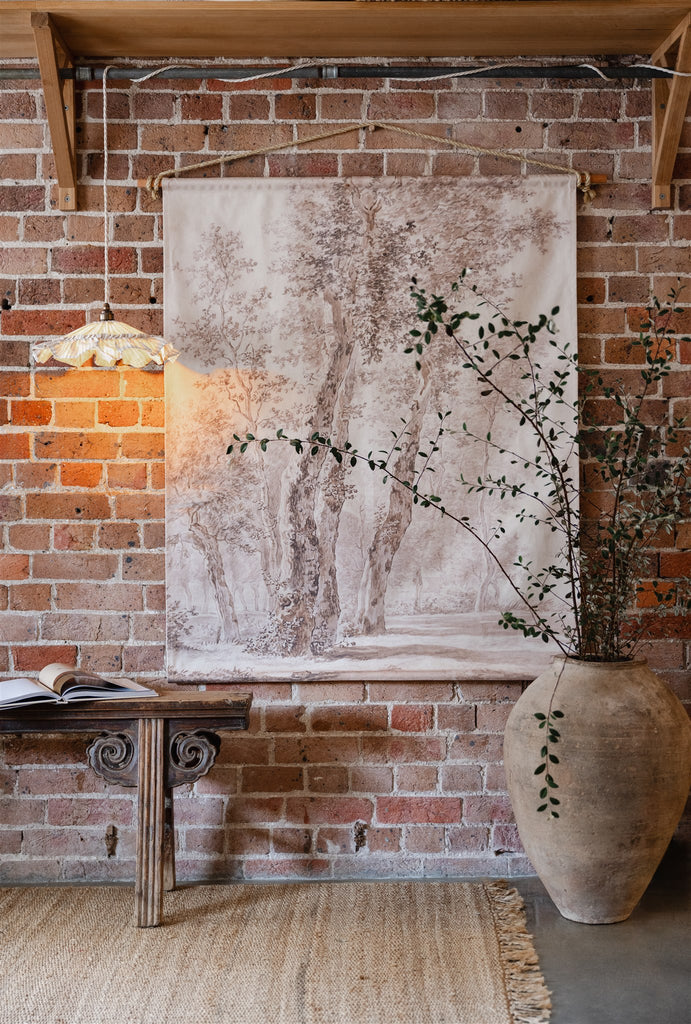 Dutch vintage style wall hanging on rustic brick wall with vintage oriental bench seat and large terracotta pot
